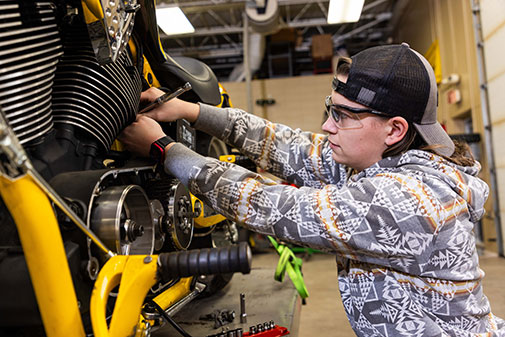 Student working on motorcycle in power sports lab
