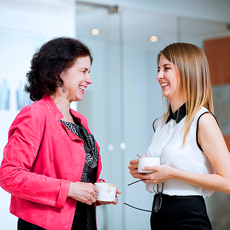 Two co-workers laughing and talking