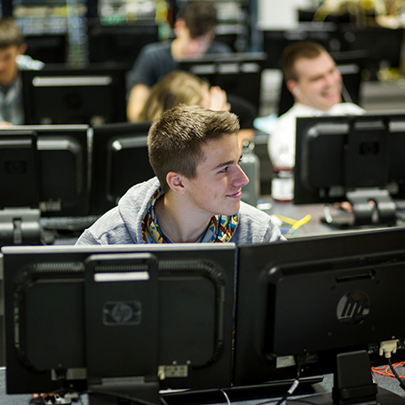 An IT student in the classroom sitting at a computer