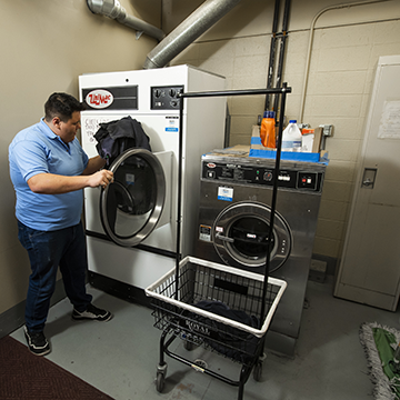 A hospitality foundation student doing laundry