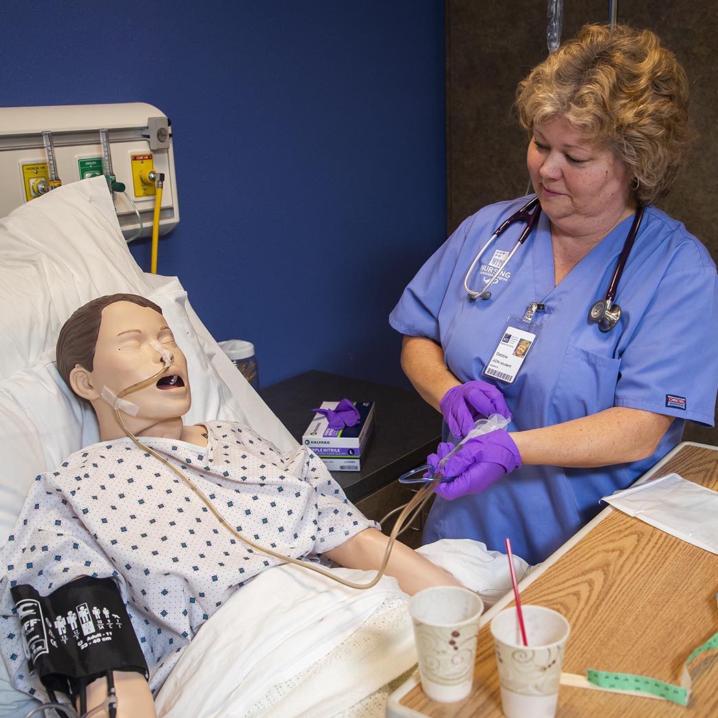 A nurse student working with a simulated patient
