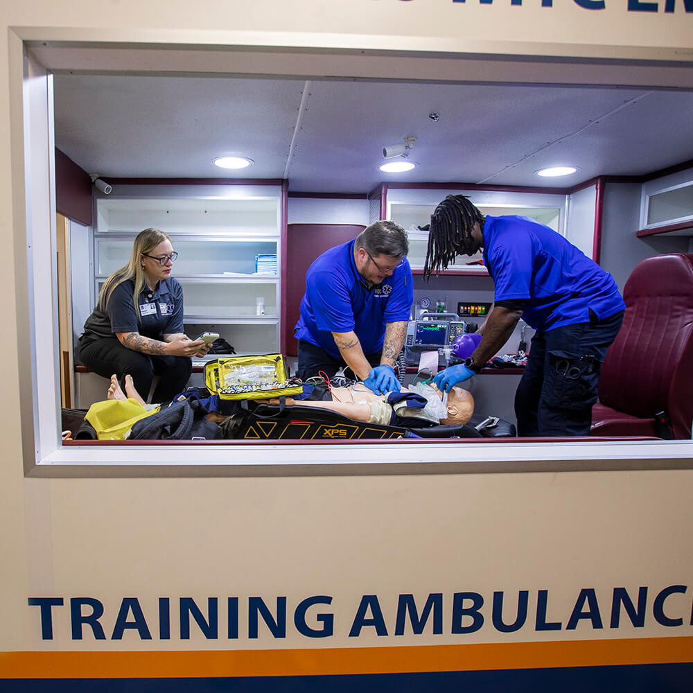 Northwood Tech students using the classroom training ambulance and practicing skills with a simulated patient