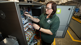 An automated packaging student working with equipment in the lab