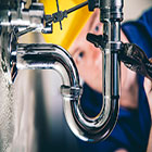 plumber working under a sink