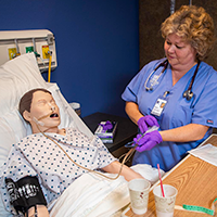 A nurse student working with a simulated patient