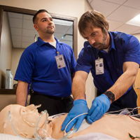 EMT-Paramedic students practicing skills on a simulated patient