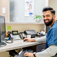 A medical office professional at his desk