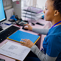 A medical administrative professional at her computer station