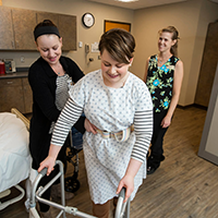 An occupational therapy assistant instructor coaching the students through a hands-on exercise