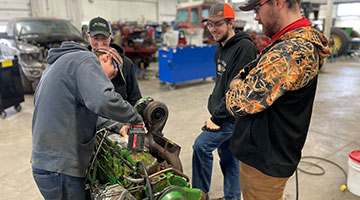 A student repairing a tractor