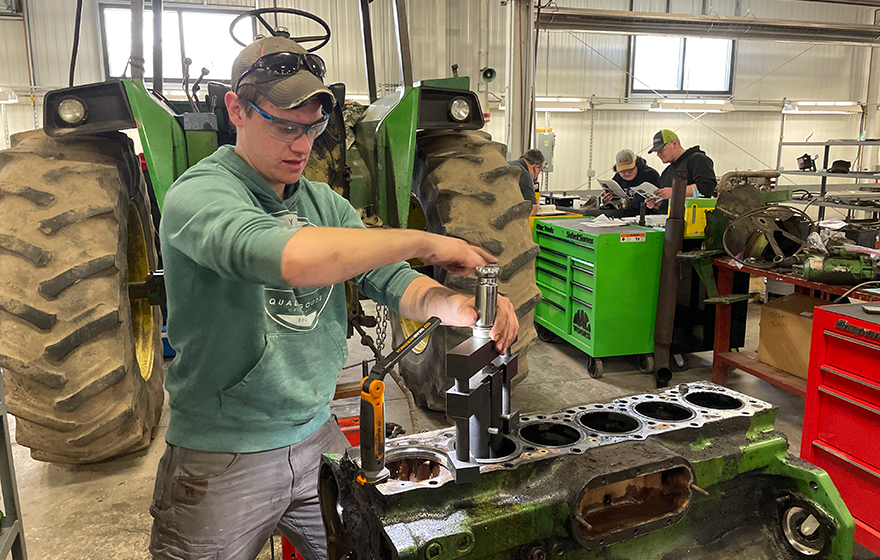 Students working on a tractor in the shop