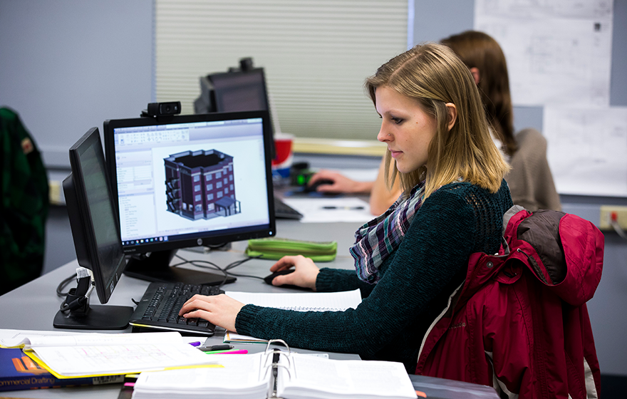 Architecture student sitting at a computer working with a drafting software