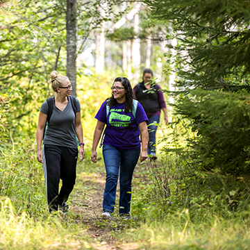 Two students walking down a path in the woods