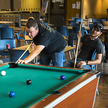 Student playing pool in the Ashland common area