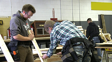 High school students doing hands-on work with construction