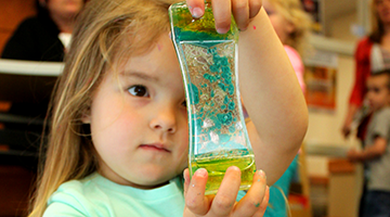 A child looking inquisitively at a toy