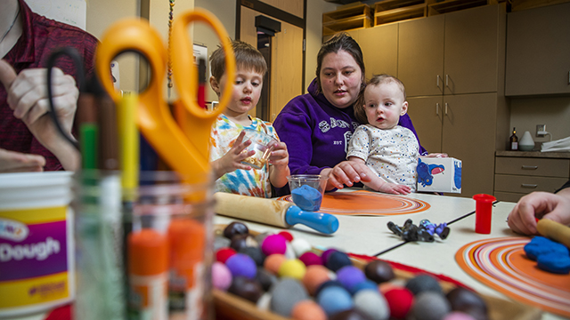 Early childhood education student and a kid playing with Play-Doh!