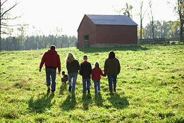 A family walking together by a barn