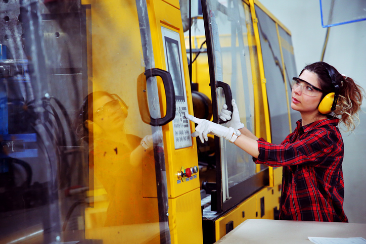 Female injection mold technician working in a shop