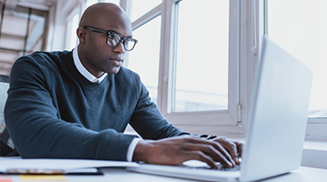 An IT professional working at a laptop