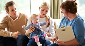 A human services technician visiting a family with a young baby