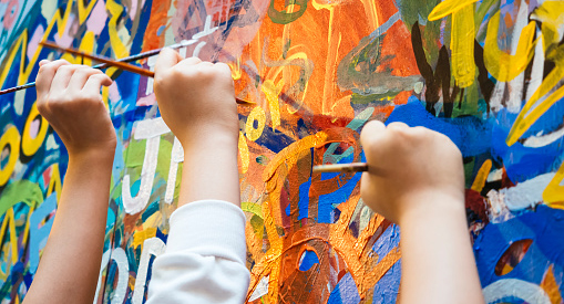 Hands painting a mural