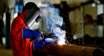 A worker welding a pipe