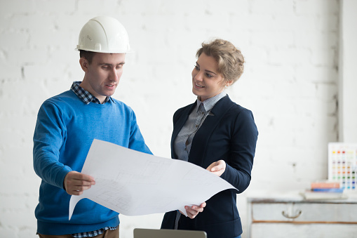 Business discussion with construction engineer in hardhat and architecture project manager