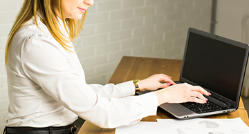 A professional using a laptop and looking at documents