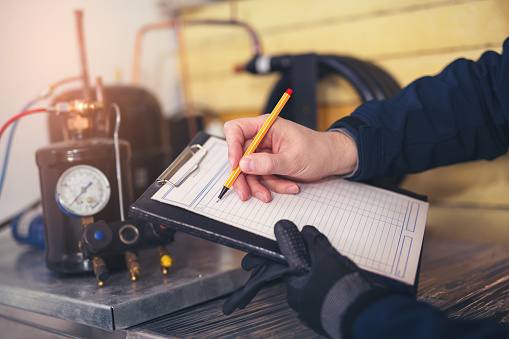 Residential HVAC/R Technician analyzing an air conditioning unit