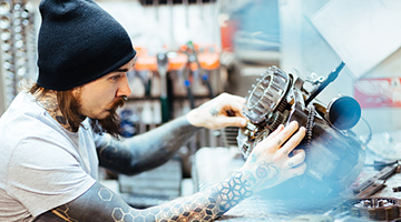 A power sports technician repairing a motorcycle engine