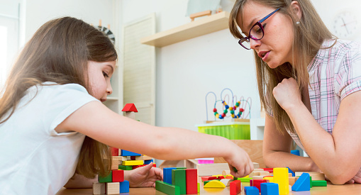 A childcare provider and child having fun time and playing