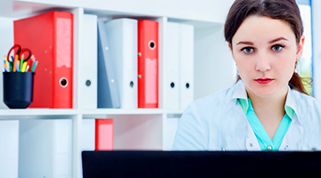 A health information technician looking at a computer screen