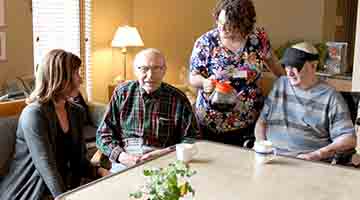 Group of people sitting at a table in a community-based residential facility
