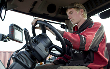 Person sitting at the wheel of a tractor