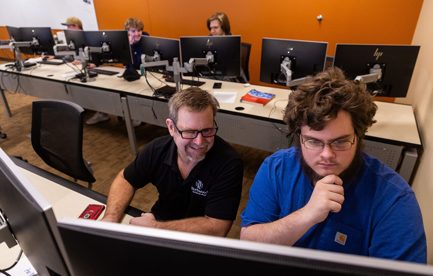 IT student and instructor working on computer programming