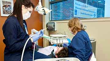 Dental Assistant student working with a real client