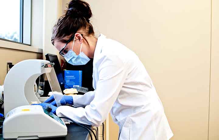 Student looking through a microscope in the dental lab