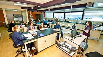 Dental assistant students in the classroom listening to the instructor speak