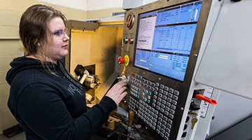 A student operating a machine