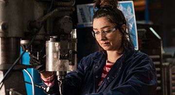 A worker at milling machine in workshop