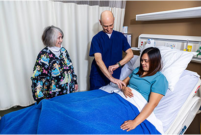 Nursing Assistant students checking vital signs while a teacher watches