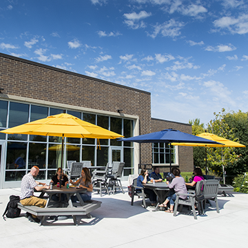 Group of people sitting at outside patio tables eating