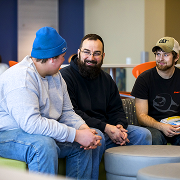 Three students hanging out in commons area at New Richmond campus