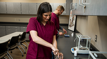 Two pharmacy technician students compounding medications