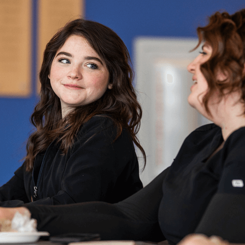 A smiling student talking to a friend