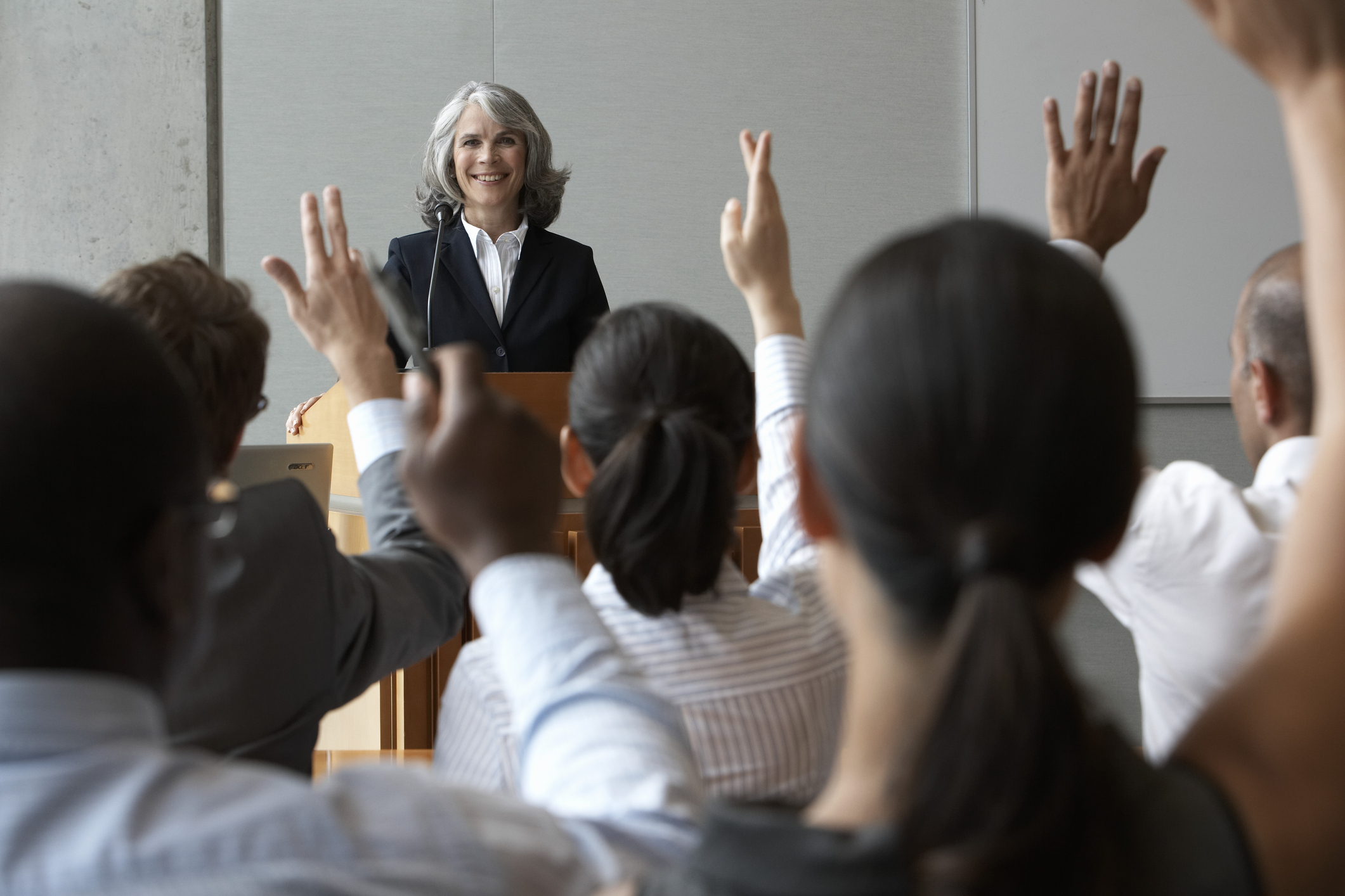 Continuing Education Professional Development Continuing Education classroom with instructor at podium and students raising their hands