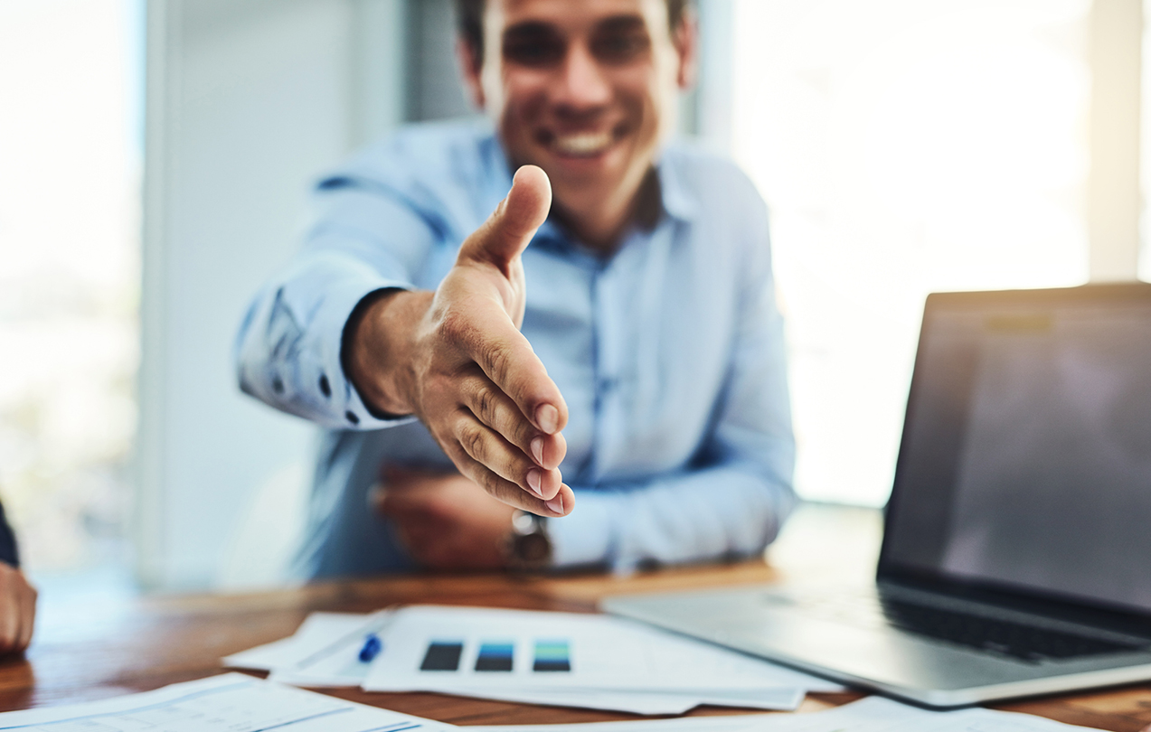 An HR worker reaching out for a handshake