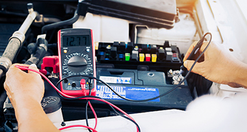 Automotive technician working with a digital multimeter