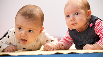 Two newborn babies having some tummy time